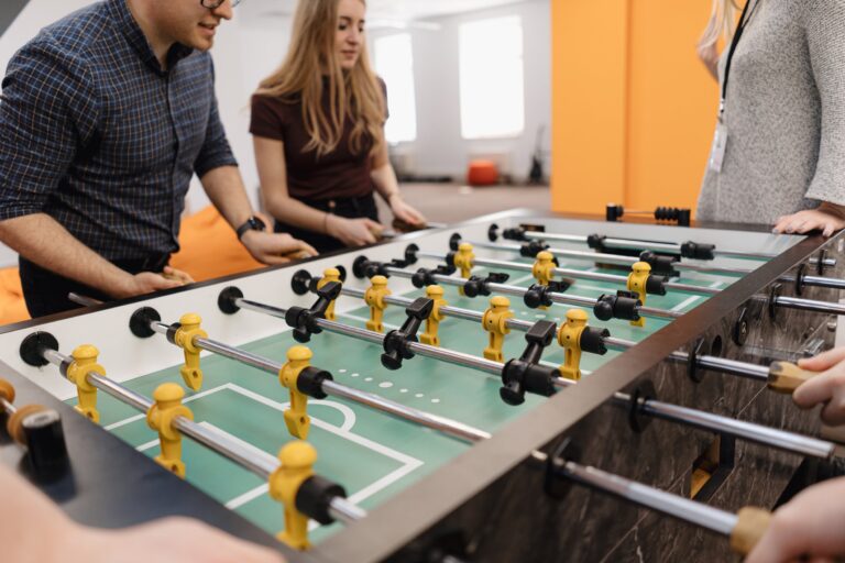 Group of Young Office Workers Playing Table Soccer Game Inside the Office During their Break time.