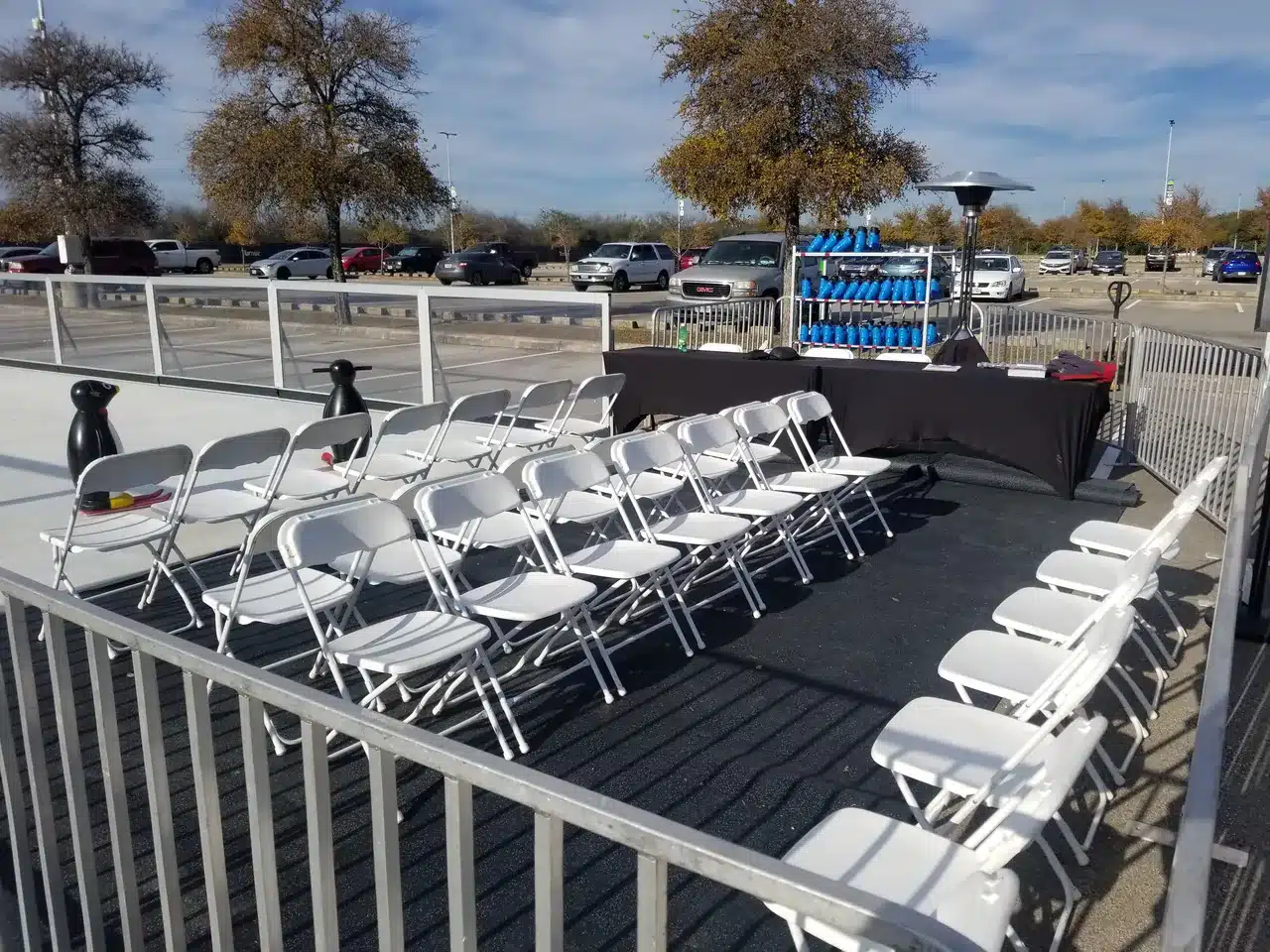A prepared skate-changing area with seating, skate racks, and skate helpers beside the rink